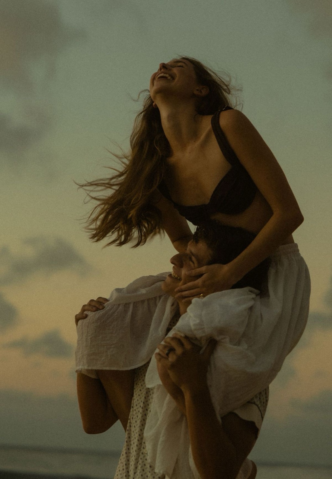 Woman on the beach at dusk with wind in her hair