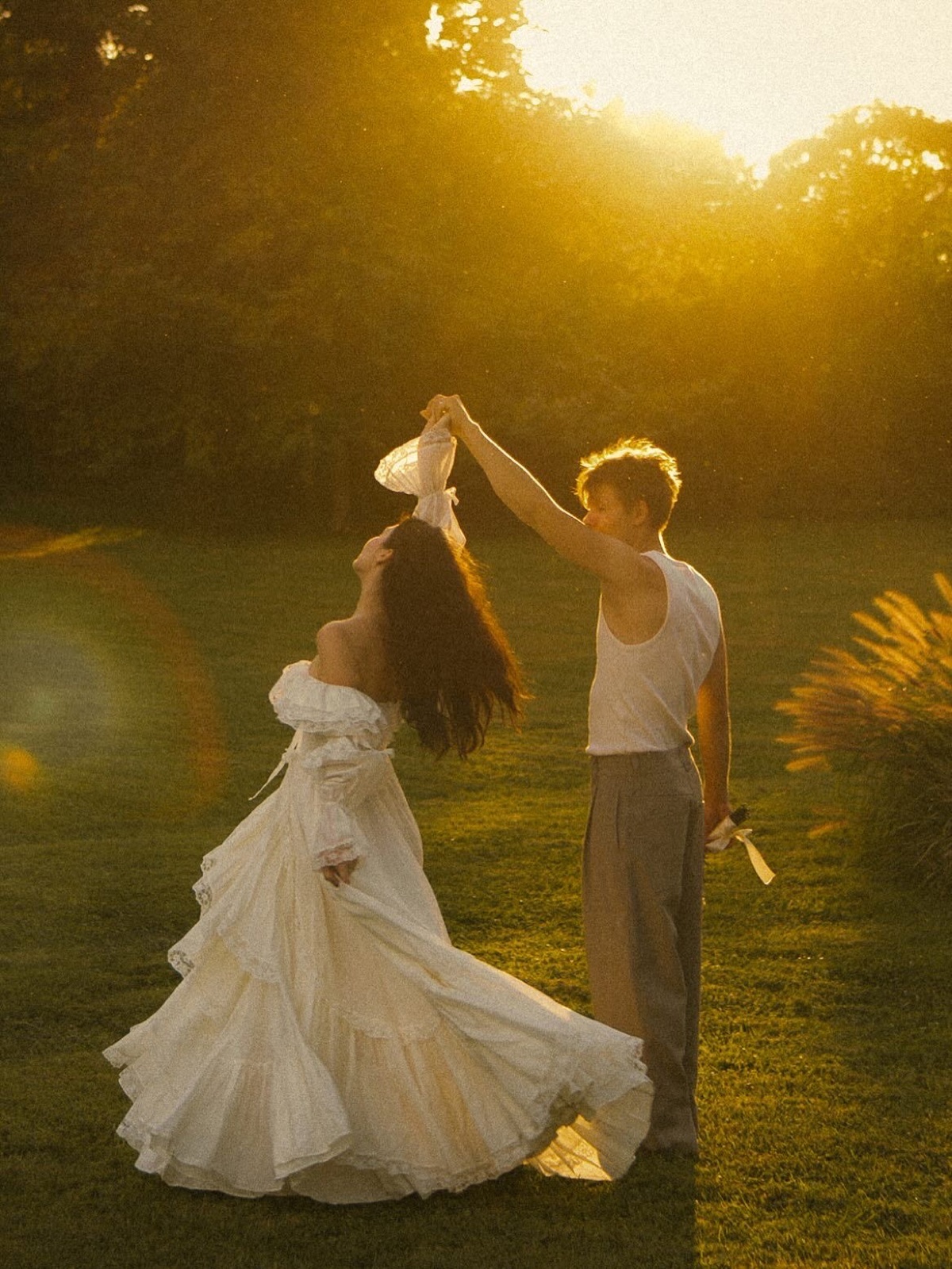 Couple dancing in a garden at golden hour