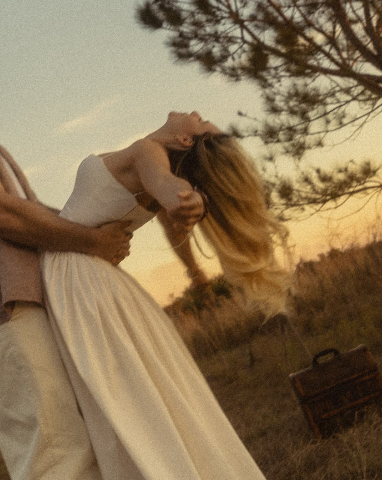 Couple embracing in a golden field at sunset