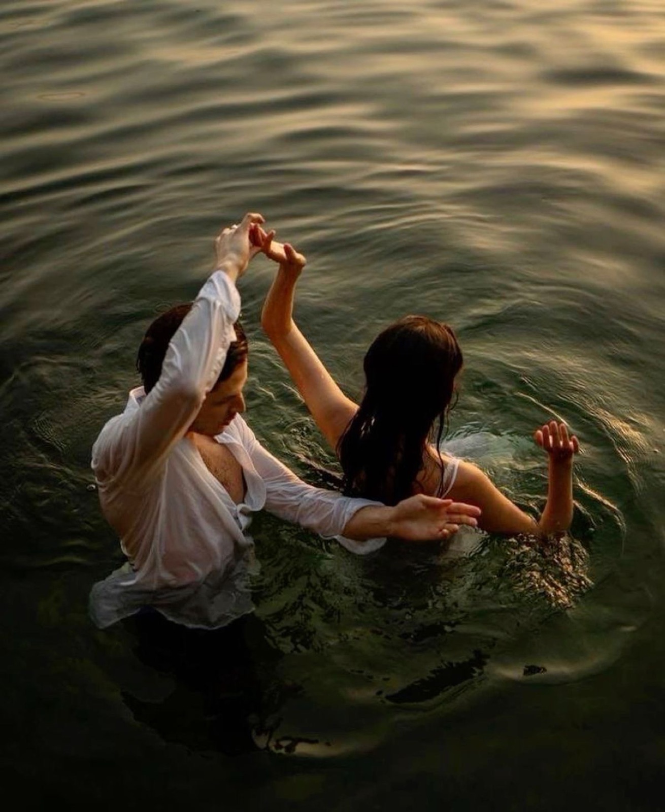 Couple swimming in a lake at dusk