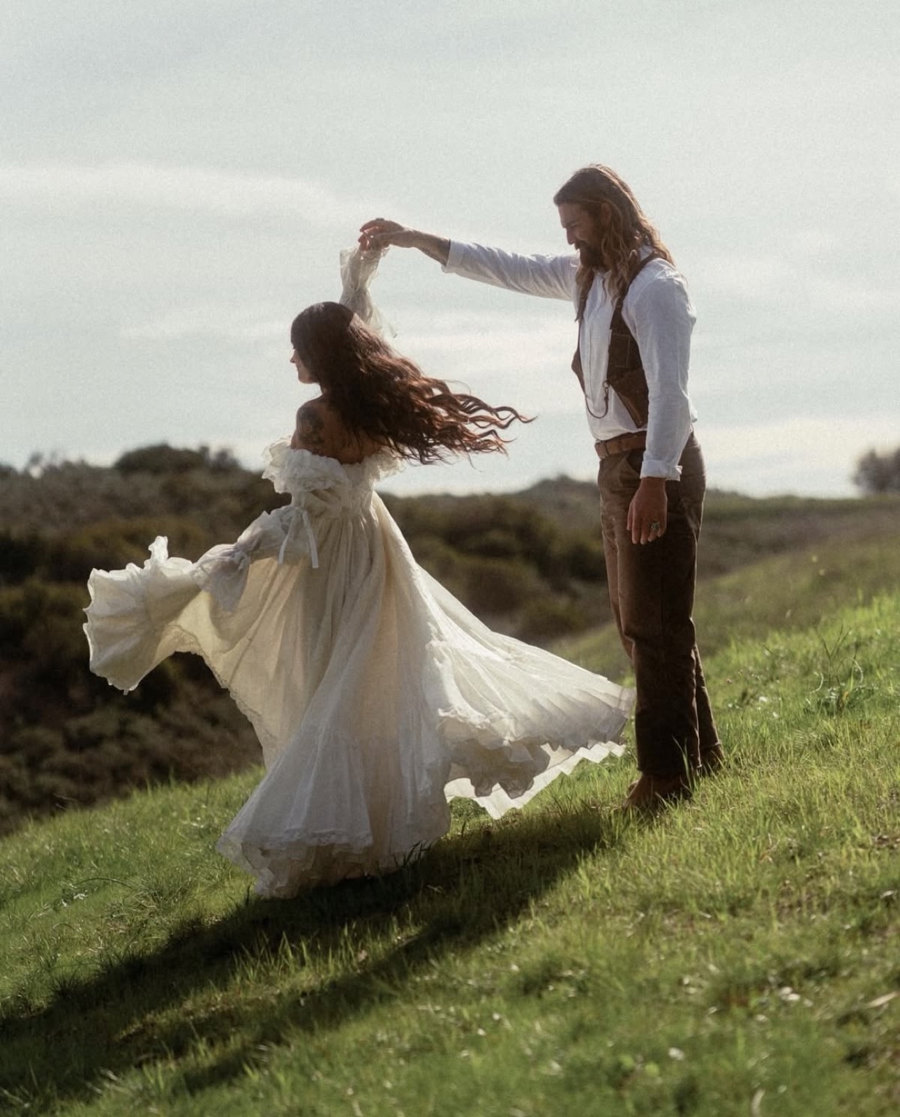 Couple dancing on a green hill