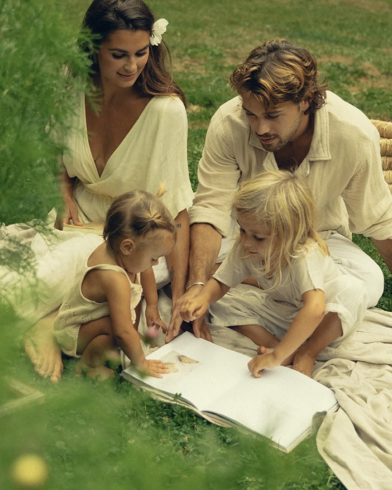 Family gathered around a picnic blanket in the grass