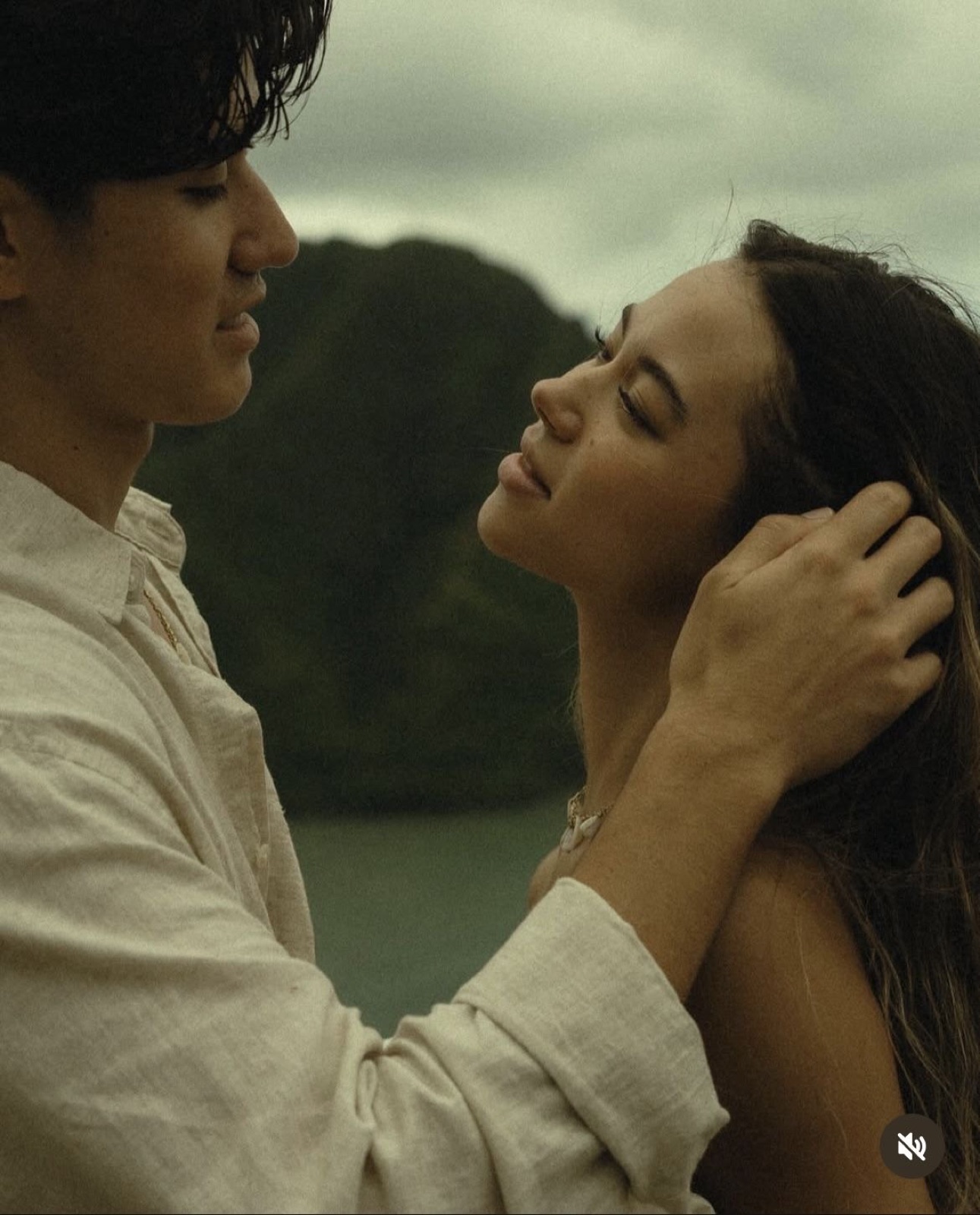 Couple embracing in front of a lake and mountains