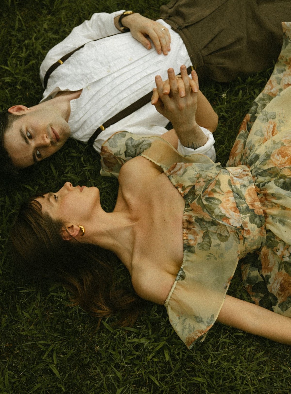 Couple lying in the grass surrounded by summer flowers